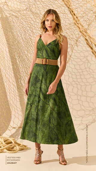 Woman wearing a green dress with a belt against a textured beige background